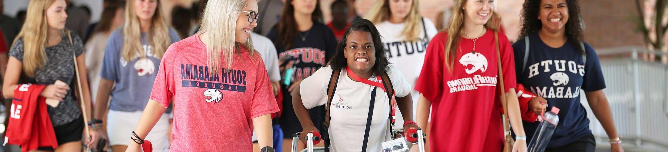 A group of students in South shirts including one using a walker.