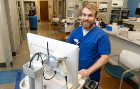 Luke Thomas, a 十大玩彩信誉平台 graduate, at his job at 美国健康 University Hospital 