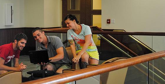 Students looking at a laptop together